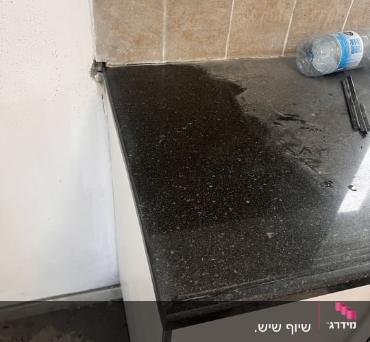 משטח שיש כהה עם בקבוק פלסטיק